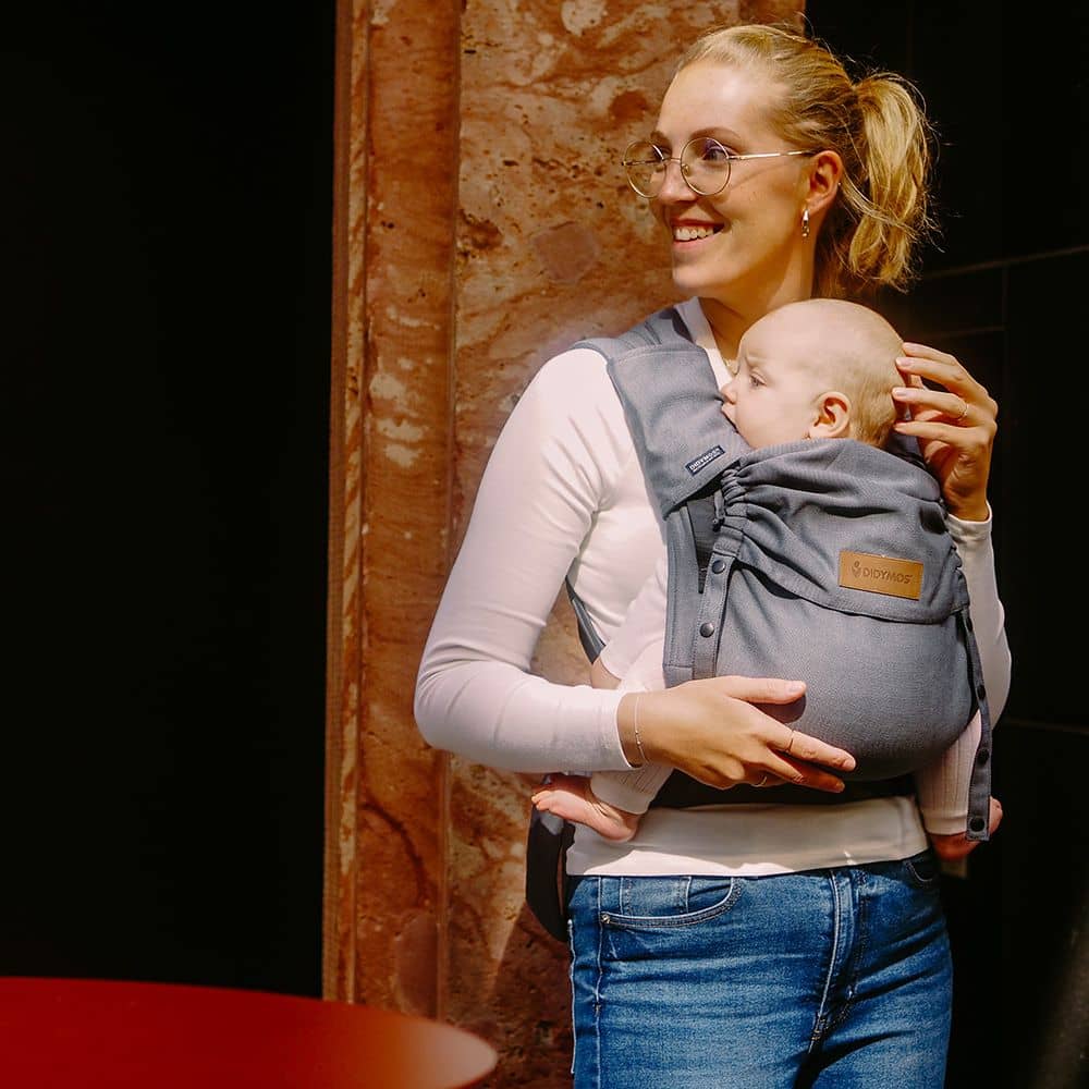 Didymos DidyFlow Babytrage – Doubleface Anthrazit – Person trägt Baby in anthrazitfarbener Trage