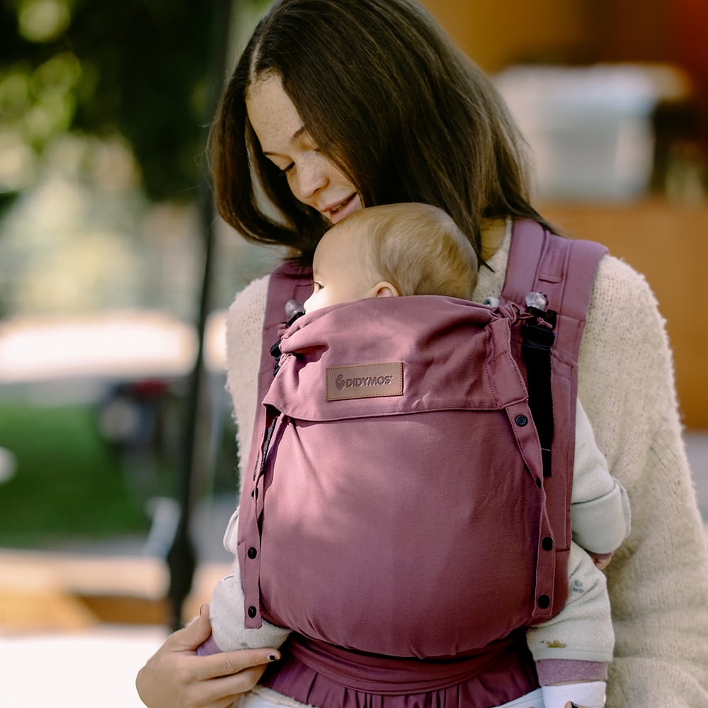 Didymos DidyFlow Babytrage – Berry – Person trägt Baby in beerenfarbener Babytrage