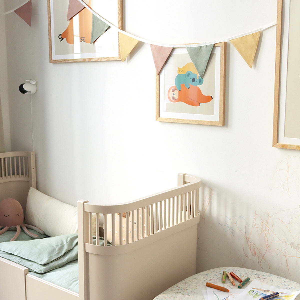 Kindsgut – Wimpelkette als Dekoration über einem Kinderbett