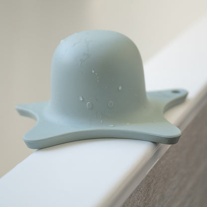 Kindsgut – aquamarinfarbene Duschhilfe am Badewannenrand