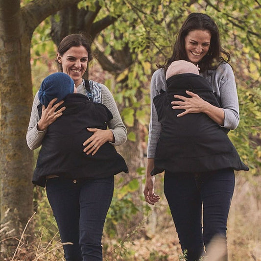 mamalila Softshell-Tragecover Allrounder – zwei Personen tragen Babys unter schwarzen Softshell-Covern