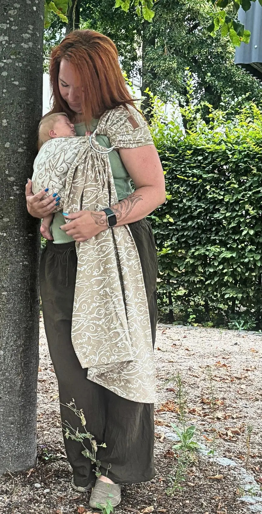 LELIBA Ring Sling – Ramus Rega – Person trägt Baby im hell gemusterten Ringsling