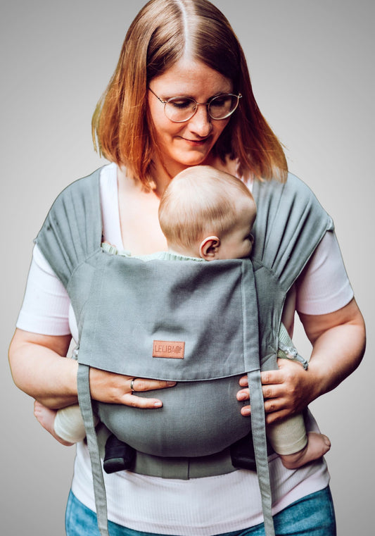 LELIBA Zack – Fullbuckle-Babytrage – Person trägt Baby in graublauer Fullbuckle-Trage